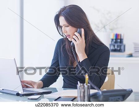 Businesswoman working at desk View Large Photo Image Stock Image - Businesswoman working at desk. Fotosearch