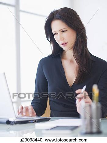 Businesswoman working at desk View Large Photo Image Stock Image - Businesswoman working at desk. Fotosearch