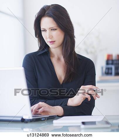 Stock Photo - Businesswoman working at desk. Fotosearch