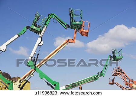 Cherry pickers on construction site View Large Photo Image Stock Image - Cherry pickers on construction site. Fotosearch