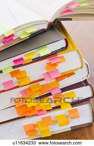 Stock Image -  Close up adhesive notes in books, studio shot. Fotosearch