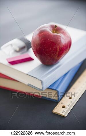 Close up apple lying on book View Large Photo Image Stock Photograph - Close up apple lying on book. Fotosearch