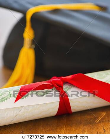 Stock Photography - Close up of diploma and mortarboard, studio shot. Fotosearch