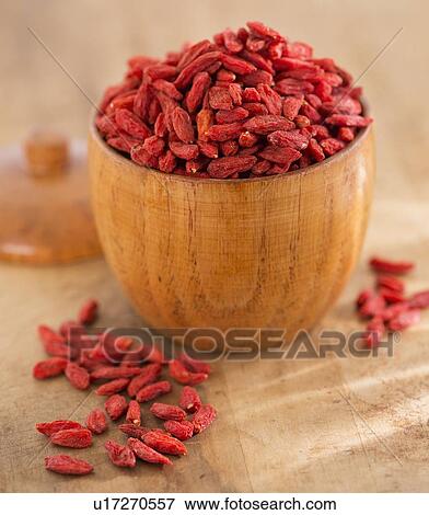 Stock Photo - Close up of goji berries in wooden bowl, studio shot. Fotosearch