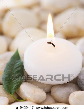 Close up of tea light and green leaf on pebble stones, studio shot View Large Photo Image Stock Photo - Close up of tea light and green leaf on pebble stones, studio shot. Fotosearch