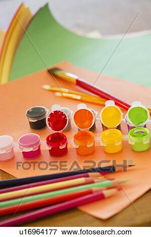Stock Photo - Close up of watercolor paints, crayons and paintbrushes, studio shot. Fotosearch