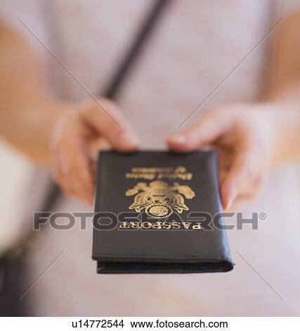 Close up of woman's hands holding passport View Large Photo Image Picture - Close up of woman's hands holding passport. Fotosearch