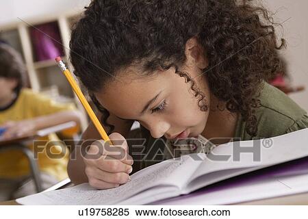 Close-up of writing girl (10-11) with boy (10-11) in background View Large Photo Image Stock Photography - Close-up of writing girl (10-11) with boy (10-11) in background. Fotosearch