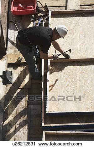 Construction worker hammering nails View Large Photo Image Stock Image - Construction worker hammering nails. Fotosearch