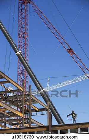 Stock Image - Construction worker on construction frame. Fotosearch
