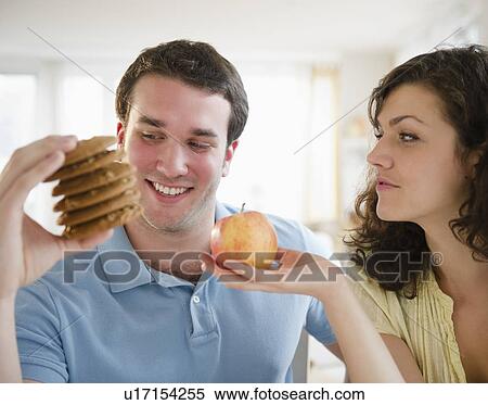 Couple holding cookies and apple View Large Photo Image Stock Photography - Couple holding cookies and apple. Fotosearch