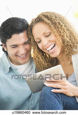 Couple looking at tablet pc View Large Photo Image Stock Image - Couple looking at tablet pc. Fotosearch