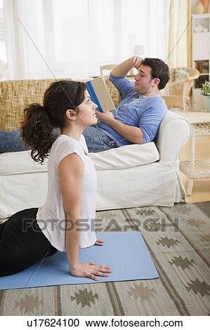 Stock Image - Couple relaxing in living room. Fotosearch