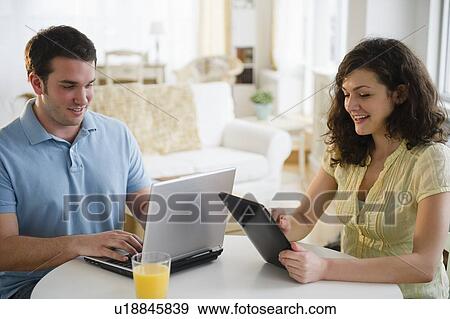 Couple using digital tablet and laptop View Large Photo Image Stock Photo - Couple using digital tablet and laptop. Fotosearch