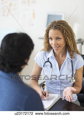 Stock Image - Doctor and patient talking in clinic. Fotosearch