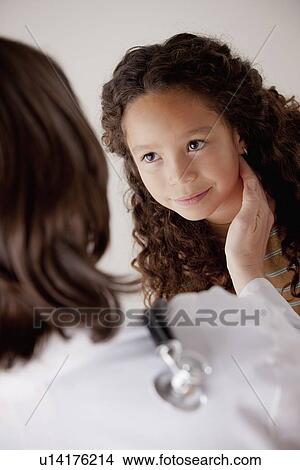 Picture - Doctor examining girl (8-9). Fotosearch