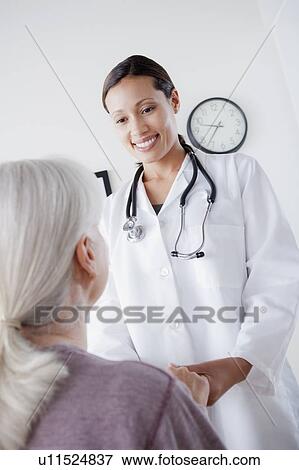 Stock Photo - Doctor talking with senior patient. Fotosearch