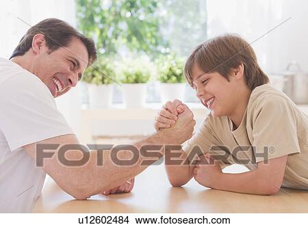 Picture - Father and son (10-11 years) arm wrestling. Fotosearch