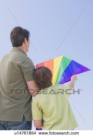 Picture - Father and son (10-11 years) playing with kite. Fotosearch