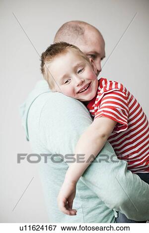 Stock Photo - Father and toddler boy (2-3) embracing. Fotosearch