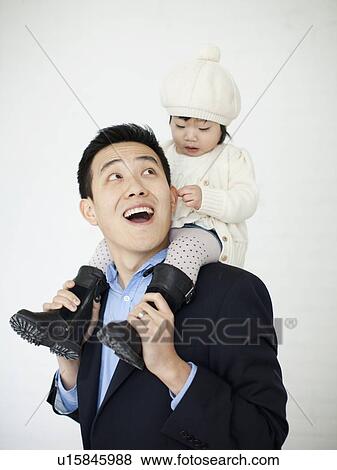Stock Photo - Father carrying baby girl (12-17 months) on shoulders. Fotosearch