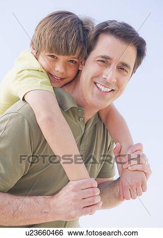 Father giving his son (10-11 years) piggyback ride View Large Photo Image Stock Photograph - Father giving his son (10-11 years) piggyback ride. Fotosearch