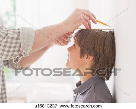 Father measuring son's (10-11 years) height View Large Photo Image Stock Photo - Father measuring son's (10-11 years) height. Fotosearch