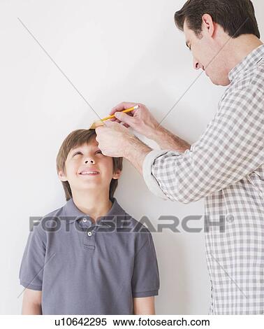 Father measuring son's (10-11 years) height View Large Photo Image Stock Photography - Father measuring son's (10-11 years) height. Fotosearch