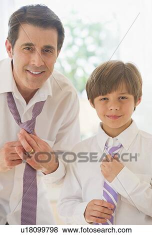 Stock Photo - Father teaching son (10-11 years) how tie tie. Fotosearch