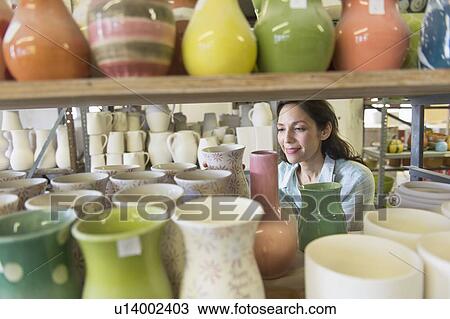 Stock Image - Female artist in pottery in studio. Fotosearch