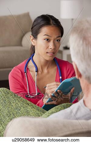 Female nurse with senior patient at home View Large Photo Image Stock Photo - Female nurse with senior patient at home. Fotosearch