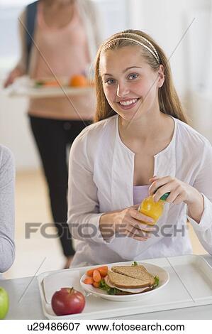 Stock Photo - Female student (16-17) having lunch. Fotosearch