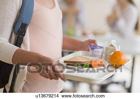 Female student carrying tray in cafeteria View Large Photo Image Picture - Female student carrying tray in cafeteria. Fotosearch