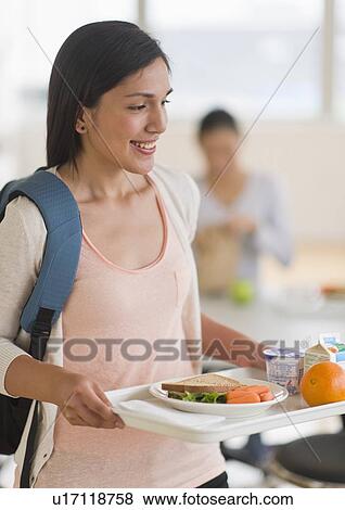 Female student carrying tray in cafeteria View Large Photo Image Stock Photo - Female student carrying tray in cafeteria. Fotosearch