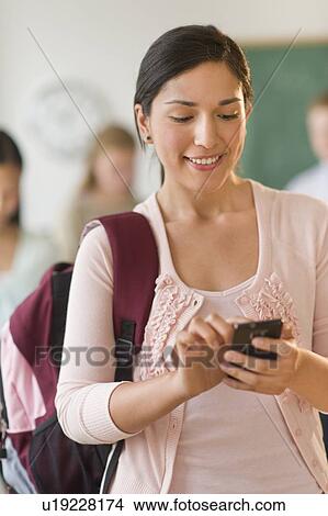 Picture - Female student texting on phone. Fotosearch