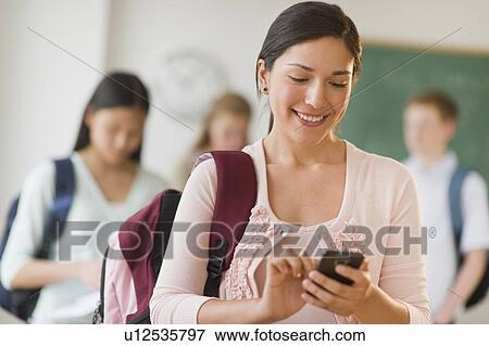 Stock Photo - Female student texting on phone. Fotosearch