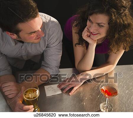 Flirting couple sitting at bar counter View Large Photo Image Stock Image - Flirting couple sitting at bar counter. Fotosearch