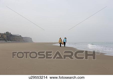 Picture - France, Pas-de-Calais, Escalles, Two women strolling on empty beach. Fotosearch