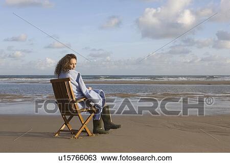 France, Pas-de-Calais, Escalles, Young woman sitting on chair on empty beach View Large Photo Image Stock Image - France, Pas-de-Calais, Escalles, Young woman sitting on chair on empty beach. Fotosearch