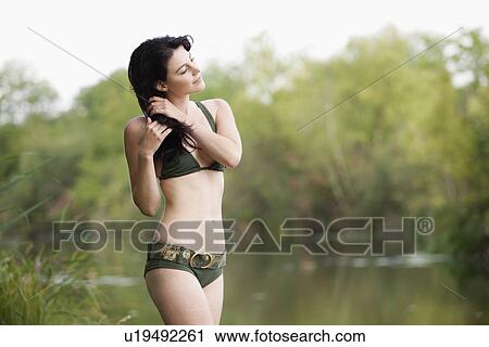 France, Picardie, Albert, Young woman in bikini standing by lake shore View Large Photo Image Stock Image - France, Picardie, Albert, Young woman in bikini standing by lake shore. Fotosearch