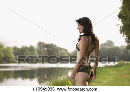 France, Picardie, Albert, Young woman in bikini standing on lake shore View Large Photo Image Stock Image - France, Picardie, Albert, Young woman in bikini standing on lake shore. Fotosearch