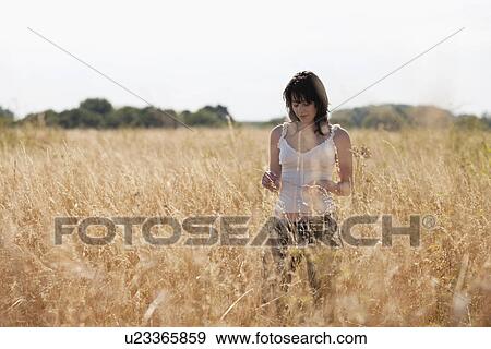 France, Picardie, Albert, Young woman strolling in cornfield View Large Photo Image Stock Photo - France, Picardie, Albert, Young woman strolling in cornfield. Fotosearch