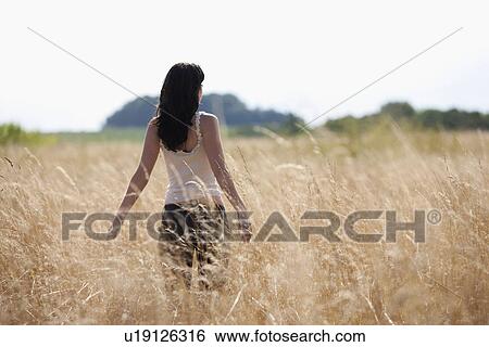 France, Picardie, Albert, Young woman strolling in cornfield View Large Photo Image Stock Photograph - France, Picardie, Albert, Young woman strolling in cornfield. Fotosearch