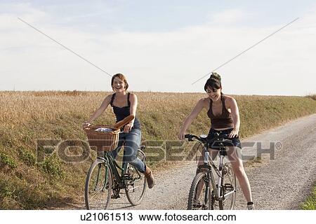France, Picardie, Albert, Young women on bikes on country road View Large Photo Image Stock Image - France, Picardie, Albert, Young women on bikes on country road. Fotosearch