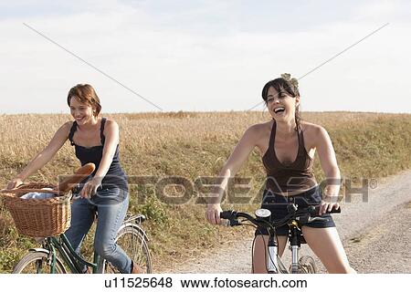 France, Picardie, Albert, Young women on bikes on country road View Large Photo Image Stock Photo - France, Picardie, Albert, Young women on bikes on country road. Fotosearch