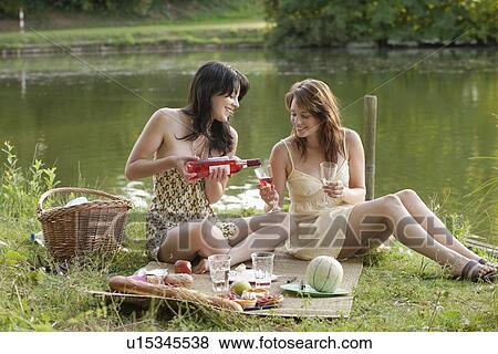 France, Picardie, Albert, Young women having picnic on lakeside View Large Photo Image Stock Photo - France, Picardie, Albert, Young women having picnic on lakeside. Fotosearch