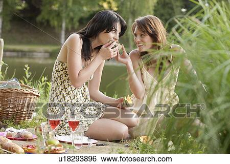 France, Picardie, Albert, Young women having picnic on lakeside View Large Photo Image Stock Photograph - France, Picardie, Albert, Young women having picnic on lakeside. Fotosearch