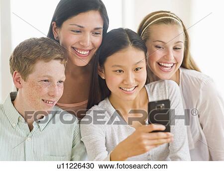 Friends (14-19) looking at mobile phone View Large Photo Image Stock Image - Friends (14-19) looking at mobile phone. Fotosearch