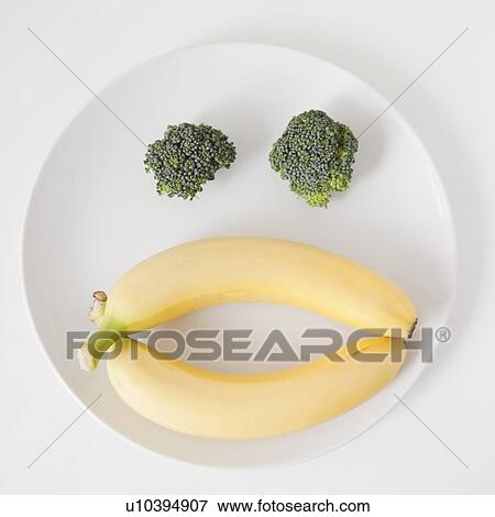 Stock Photo - Fruit and vegetable face on plate, studio shot. Fotosearch