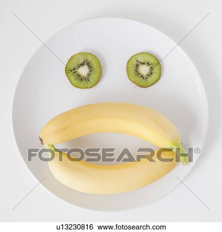Stock Photograph - Fruit face on plate, studio shot. Fotosearch